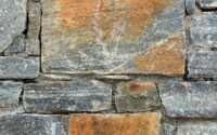 Close-up of a rustic stone wall with varied colors.