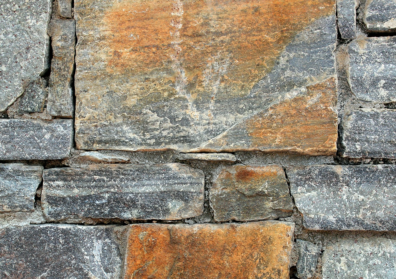 Close-up of a rustic stone wall with varied colors.